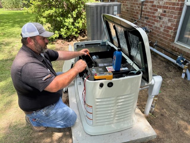 HMC technician servicing an open standby generator.