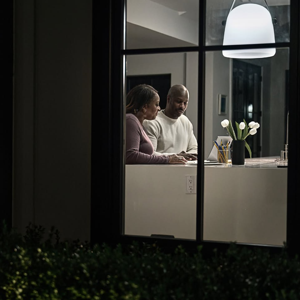 Homeowners reviewing generator financing options at a kitchen counter